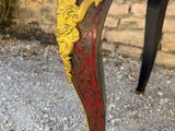 an image of a red and gold painted table with a lion head on top of it