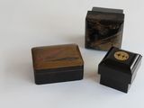 trois boîtes posées sur une surface blanche
