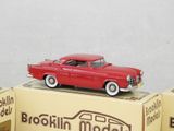 a red toy car sitting on top of a box