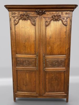une vieille armoire en bois avec des gravures et des sculptures sur les portes