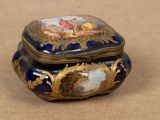 a blue and gold box with a painting on it