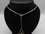un mannequin noir portant un collier en argent