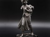 statue d'une femme tenant un panier de fleurs sur fond noir