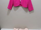 une veste rose sur un cintre, à côté d'un short