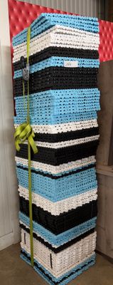a stack of baskets with a green ribbon tied to them