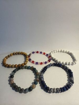 a group of five bracelets sitting on top of a white surface