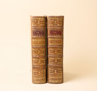 deux vieux livres posés l'un sur l'autre sur une surface blanche