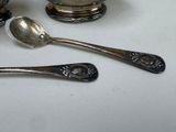 two silver spoons and a silver bowl on a table