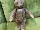 un ours en peluche assis sur un canapé vert