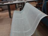 un banc blanc dans une pièce où se trouvent de nombreuses chaises