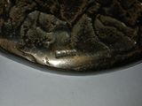 a metal bowl with a design on it sitting on a table