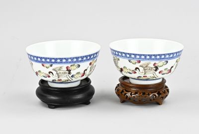 paire de bols en porcelaine chinoise posés sur un socle en bois, sur fond blanc