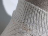 a close up of a mannequin wearing a white sweater