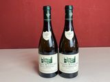 deux bouteilles de vin posées sur une table l'une à côté de l'autre