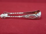 une cuillère en argent posée sur une nappe rouge, avec une cuillère au milieu