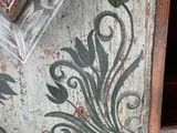 a wooden cabinet with a floral design painted on it