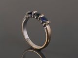 a gold and silver ring with three blue sapphire stones