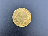 a close up of a gold coin on a black surface