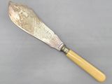 an old silverware knife with a wooden handle on a gray surface