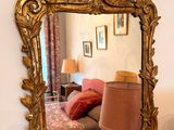 a mirror hanging on the wall above a bed