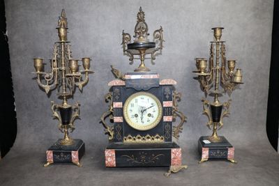 trois horloges différentes et trois lustres sur la table