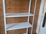 a white shelf in the corner of a room
