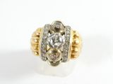 a close up of a gold and diamond ring on a white surface