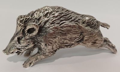 un gros plan sur une figurine en argent représentant un sanglier