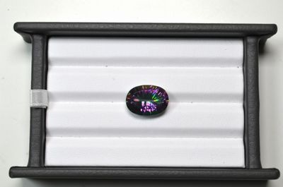 une pierre en verre noire et violette dans un coffret noir
