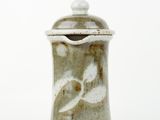 a close up of a ceramic container on a white surface