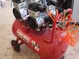 a red air compressor sitting on top of a red cart
