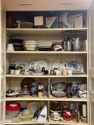 un placard rempli de vaisselle et de plats dans la cuisine