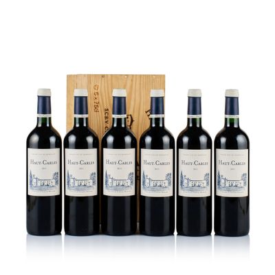 four bottles of red wine in front of a wooden box