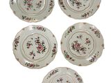 four plates with floral designs are arranged on a white surface