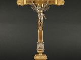 une croix en or surmontée d'un crucifix