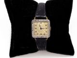 un oreiller noir sur lequel repose une montre en or