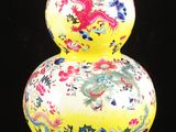 un vase jaune orné d'un dragon sur fond noir