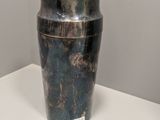 un vase en argent posé sur une table blanche