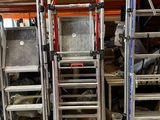 de nombreuses échelles empilées dans un entrepôt