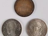 three different coins are shown on a white surface with a blue background
