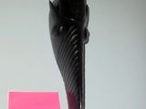 a small black object with horns on it next to a pink post - it