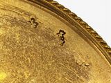 a close up of a gold plate with numbers on it