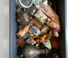 une boîte bleue remplie d'objets divers posée sur une surface blanche
