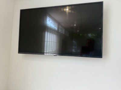 une télévision à écran plat fixée au mur dans un coin de la pièce