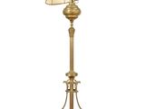 a gold floor lamp with a beige shade on top of it