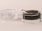 a small glass jar with a spoon in it and a small glass jar with a spoon in it