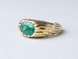 l'image d'une bague en or ornée d'une pierre verte