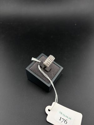 une photo d'une bague posée sur une boîte noire, avec une étiquette de prix accrochée dessus