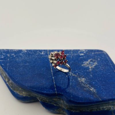 an image of a red and white diamond ring on a blue stone