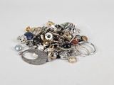 a pile of assorted jewelry on a white surface